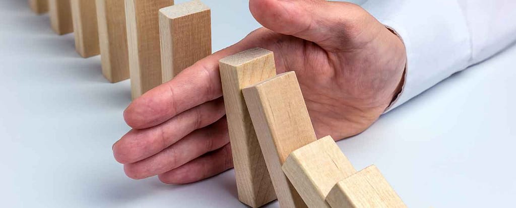 Longevità, patologie e dolore cronico. L'importanza della prevenzione.
Una mano blocca i pezzi di un domino che a catena stanno per cadere, in segno di prevenzione.