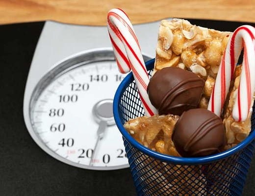 Su di una bilancia pesa persone, un cestino di dolciumi