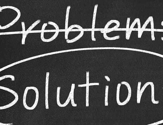 Come se fossero state scritte con un gesso bianco su di una lavagna, si leggono le parole "problems" barrata e "solutions" cerchiata